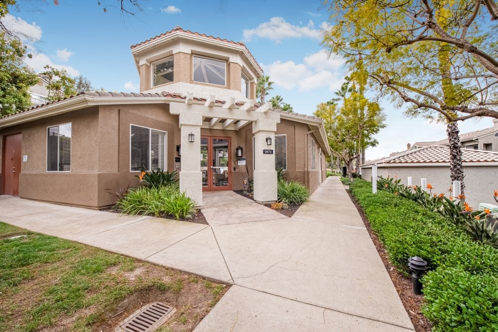 A building with a brown facade and a white column in front.