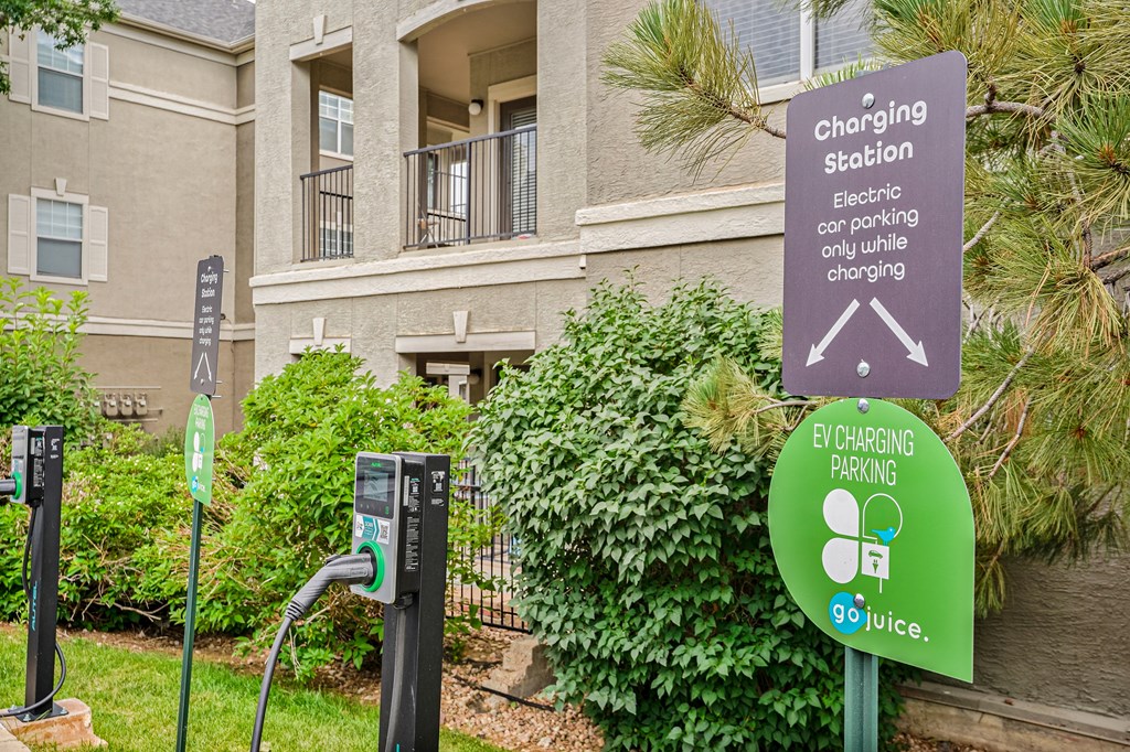 An electric car charging station sign is displayed in front of a building.