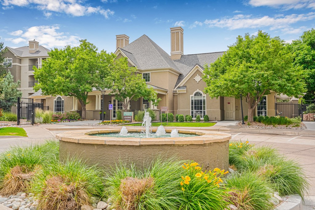 A large house with a fountain in front of it.