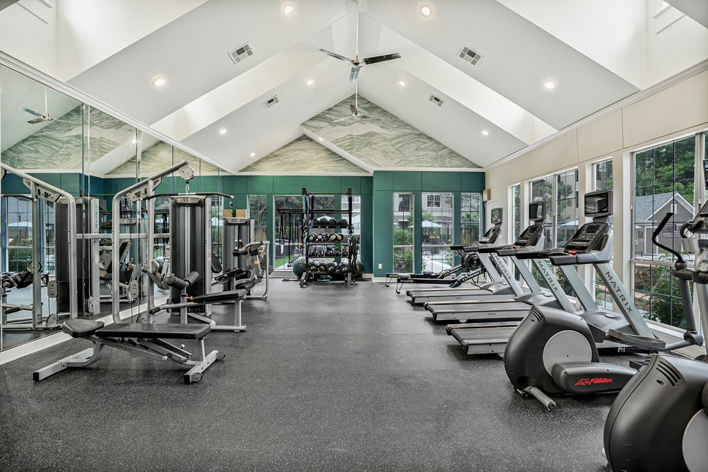 A gym with treadmills, elliptical machines, and other exercise equipment.