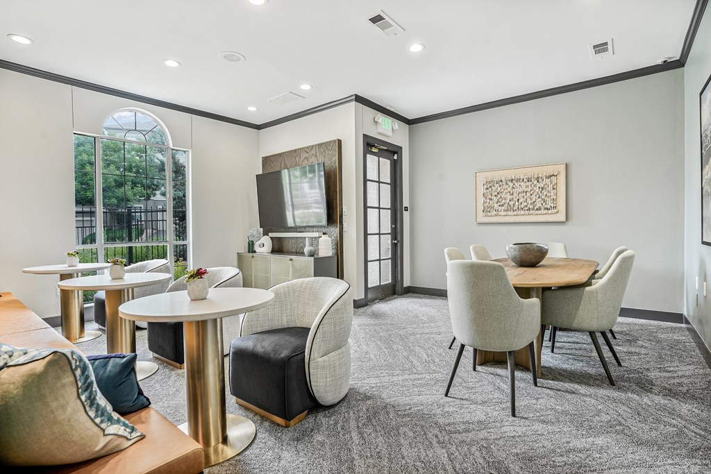 A modern dining room with a round table and chairs.