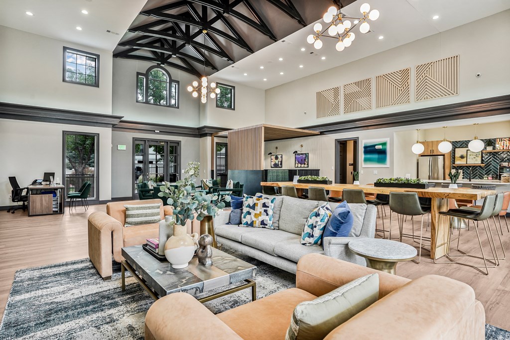 A modern living room with a large sofa, coffee table, and a dining table.