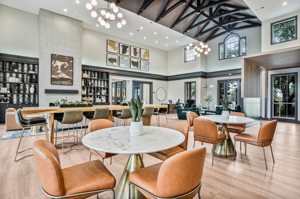 A large room with a round table and chairs in the center.