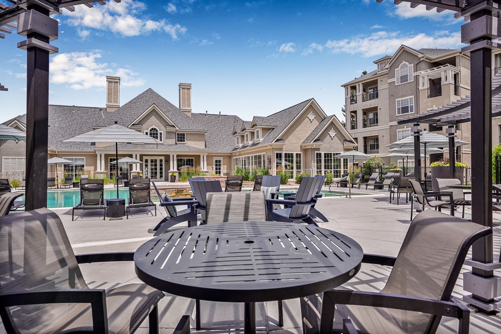 A black table with chairs around it in front of a building.