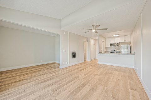 A spacious room with wooden flooring and a ceiling fan.