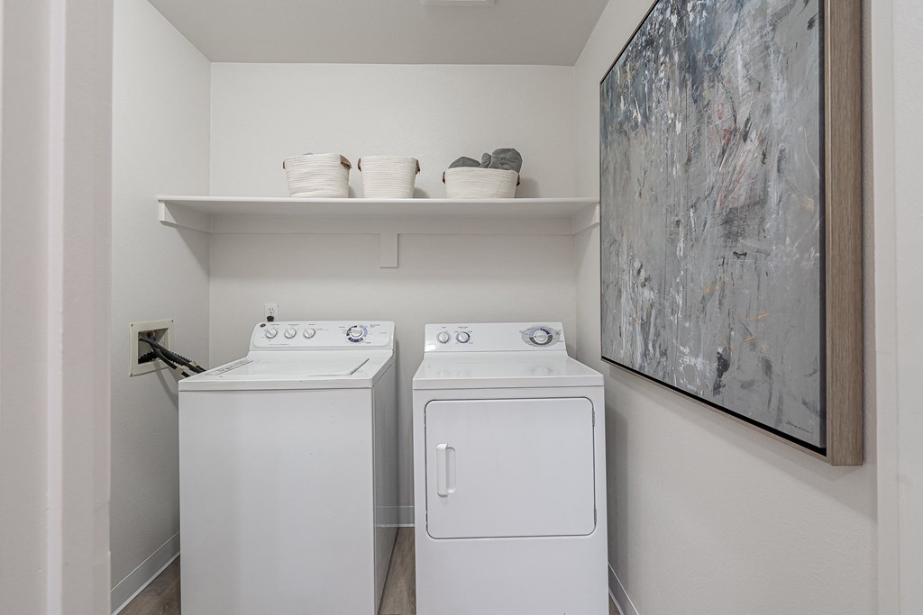 a washer and dryer in a laundry room with a painting