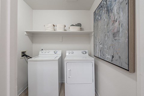 a washer and dryer in a laundry room with a painting