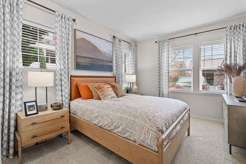 a bedroom with a bed and two windows