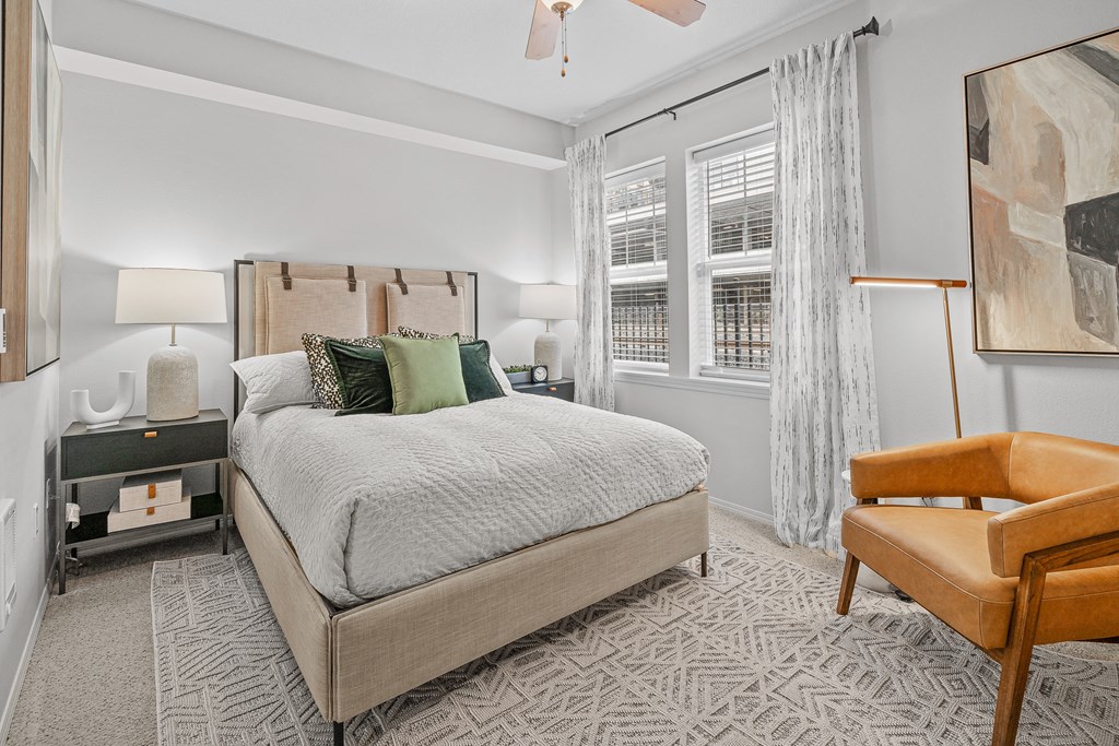 a bedroom with a bed and a chair and a window