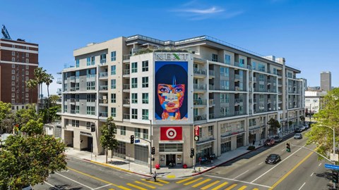 A street view of a building with a large advertisement on the side.