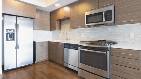 A modern kitchen with a stainless steel refrigerator and oven.