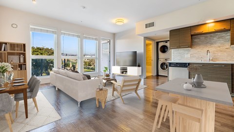A modern kitchen and living room with a dining table and chairs.