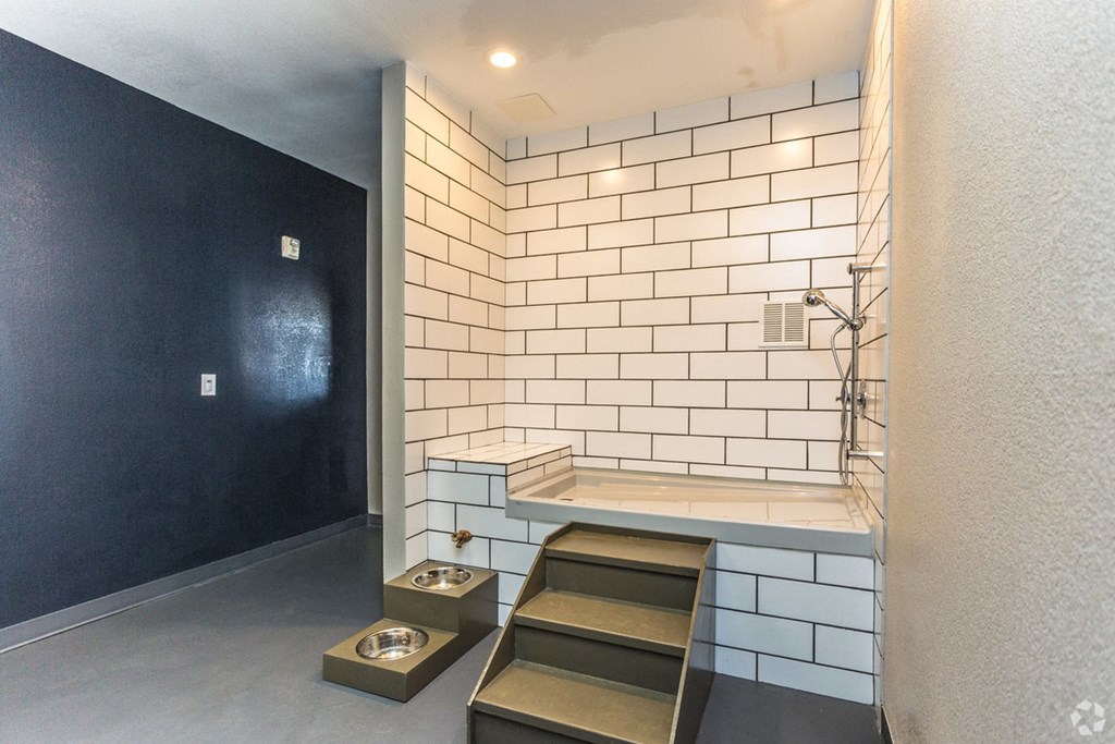 a small bathroom with white tiles and a black wall at The Viridian Apartments, Greenwood Village 80111