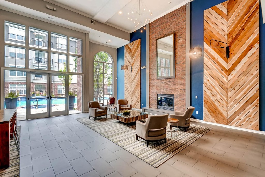 a lobby with a fireplace and chairs and a rug at The Viridian Apartments, Greenwood Village
