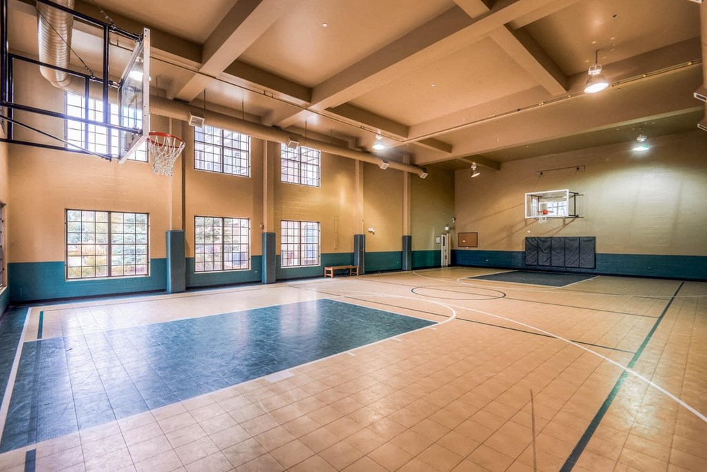 a basketball court in an empty gym with a basketball hoop at The Viridian Apartments, Colorado