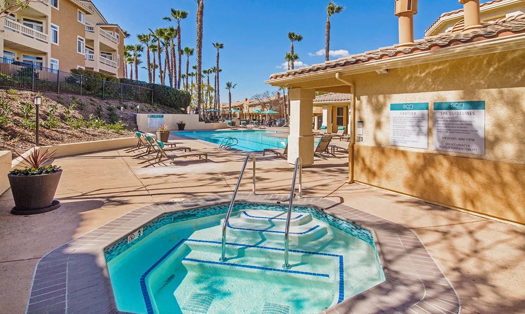 our hot tub and pool are next to a building with palm trees