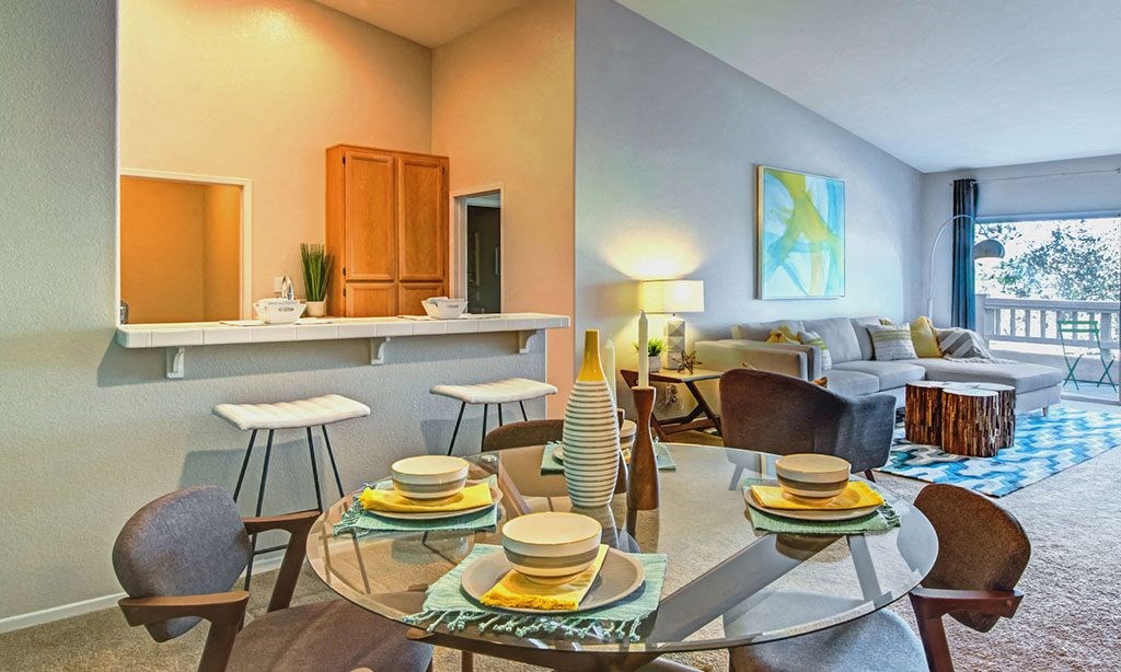 a living room and dining room with a glass table
