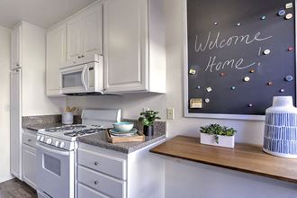 a white kitchen with a chalkboard and a stove