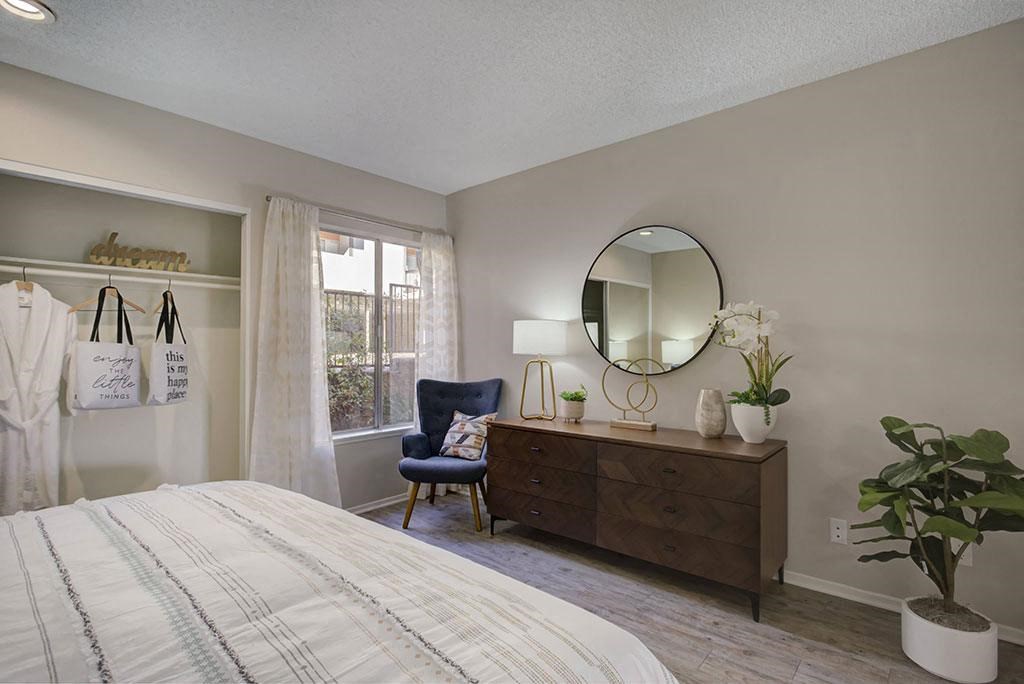 a bedroom with a bed and a dresser with a mirror