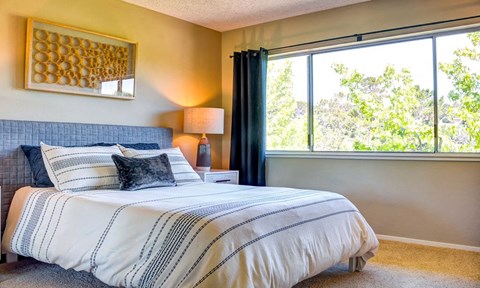 a bedroom with a bed and a large window