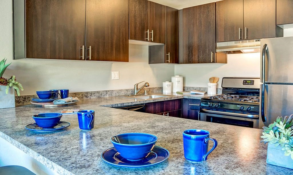 a kitchen with a counter with blue cups on it