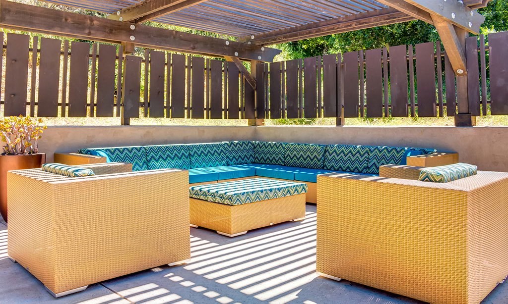 a patio with rattan furniture and a pool
