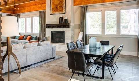 a living room with a couch table and chairs and a fireplace