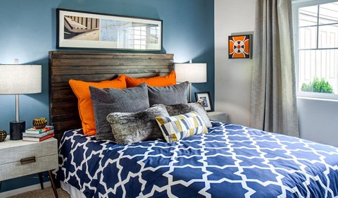 a bedroom with a bed with a blue and white comforter and pillows