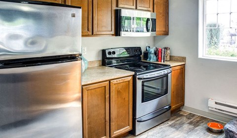 a kitchen with stainless steel appliances and wooden cabinets