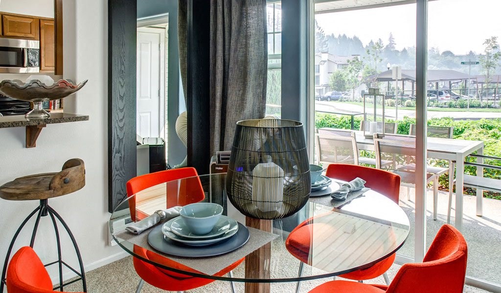 a dining room with a glass table and chairs
