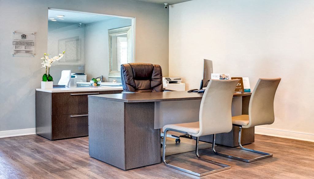 a office with a desk and chairs and a mirror