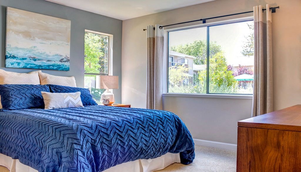 a bedroom with a bed and a large window