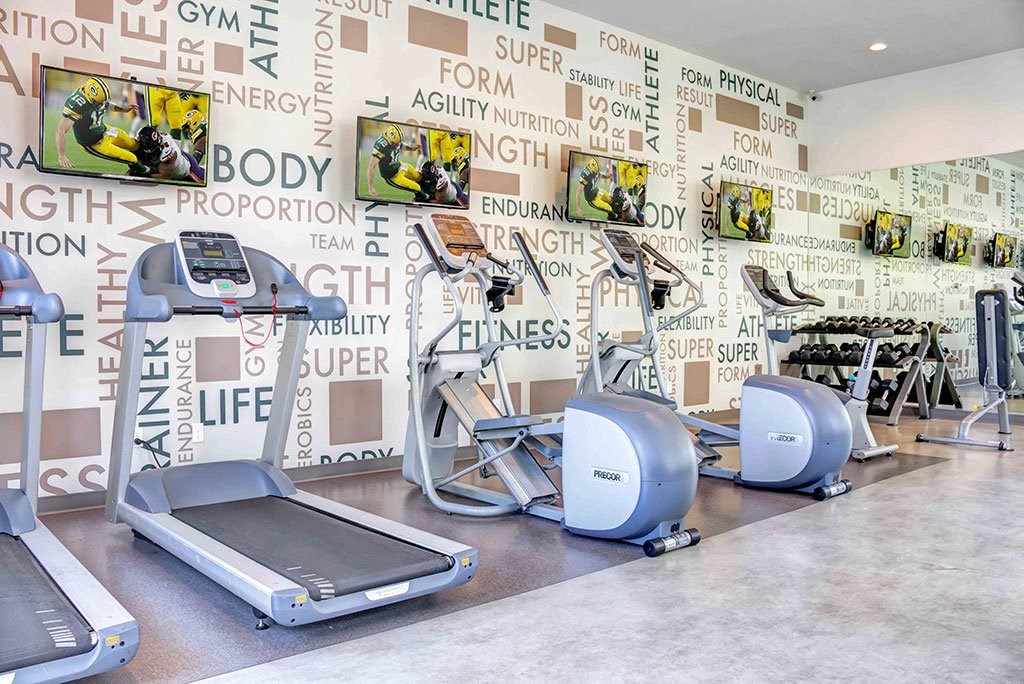 a gym with various machines and walls covered in words