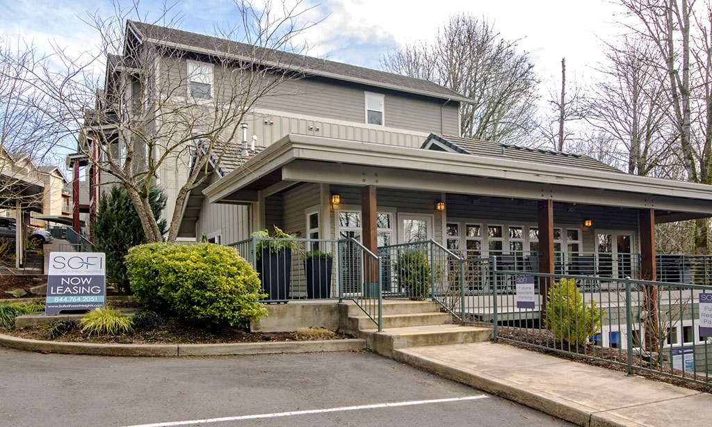 a house with a porch and a sign in front of it