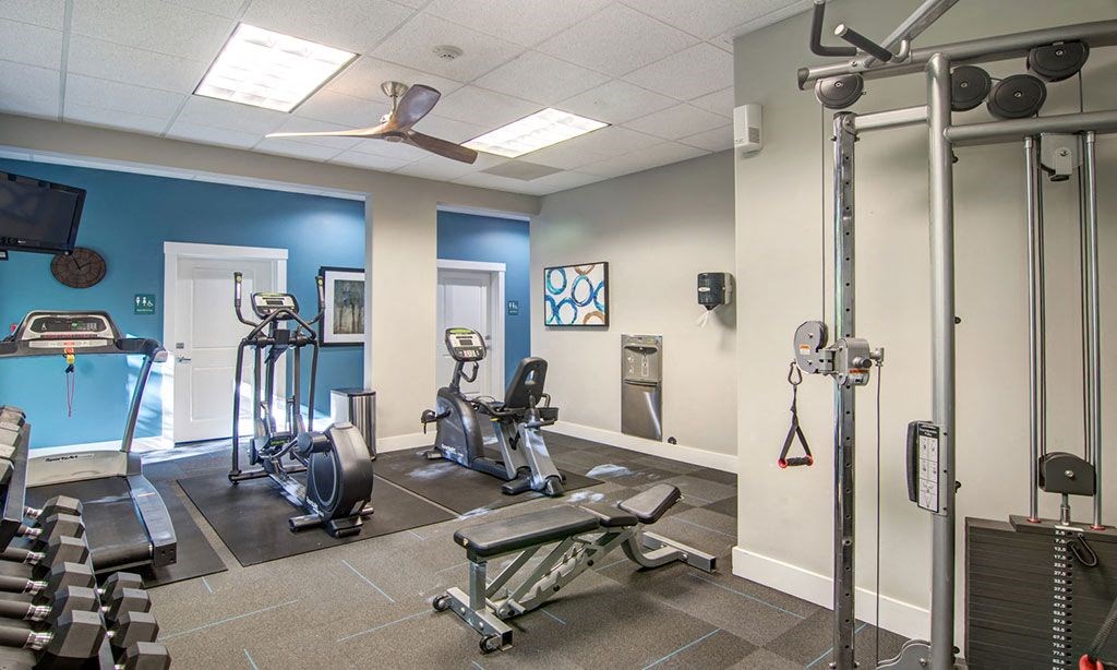a gym with weights and cardio equipment in a building
