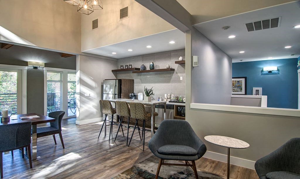 a living room and kitchen with a table and chairs
