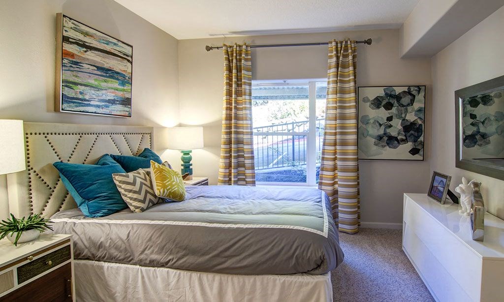 a bedroom with a bed and curtains and a window