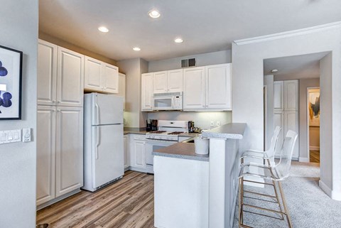 a kitchen with white cabinets and a white refrigerator