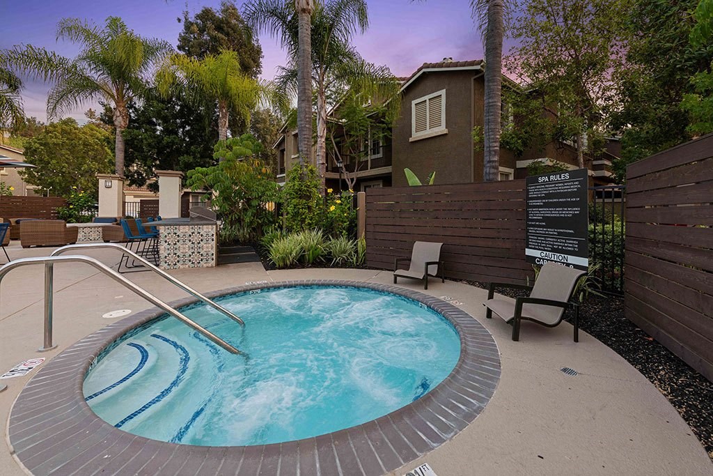 a hot tub in a backyard with a house in the background