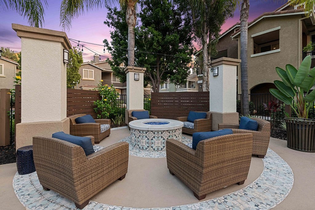 a patio with wicker furniture and a fire pit