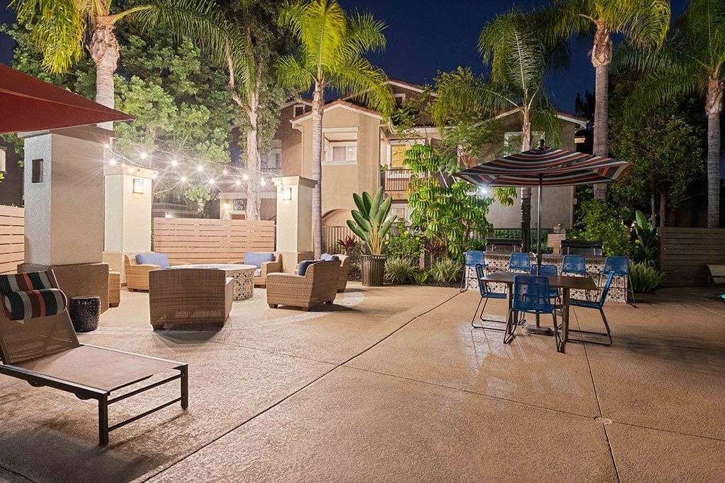 a patio with tables and chairs at night