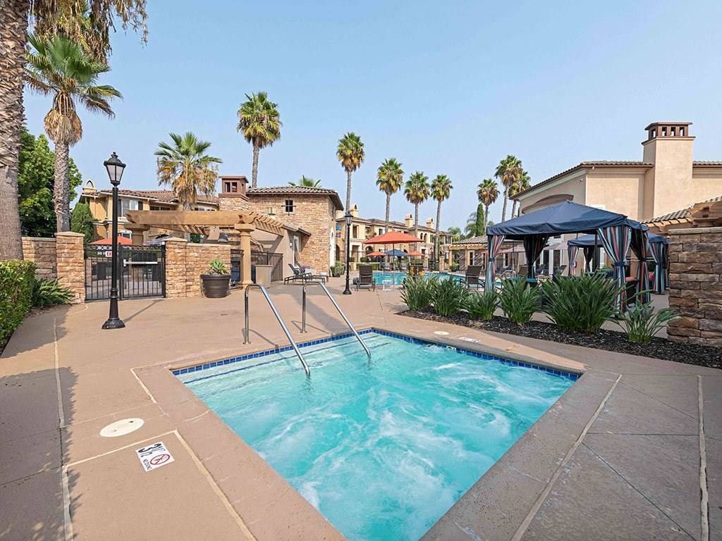 a swimming pool with palm trees and a building in the background