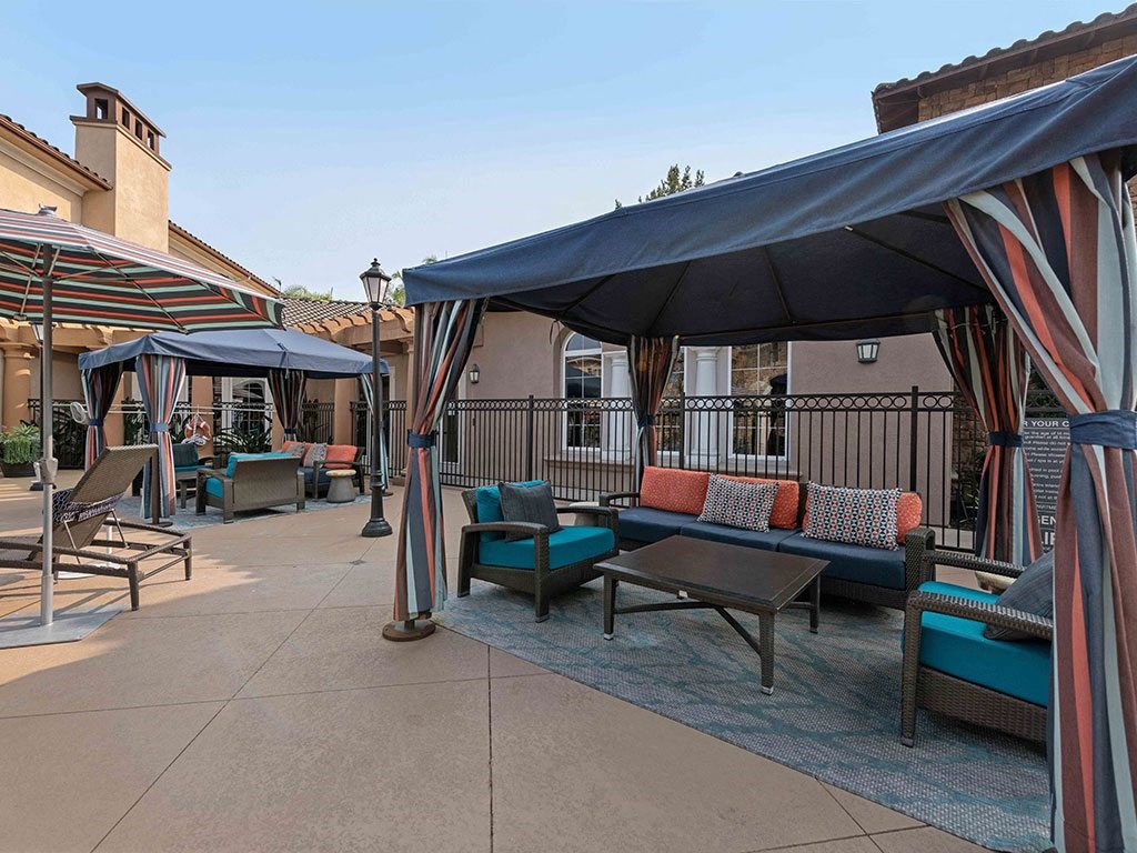 a patio with tables and chairs and umbrellas