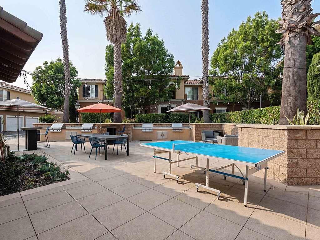 a ping pong table on a patio with tables and chairs