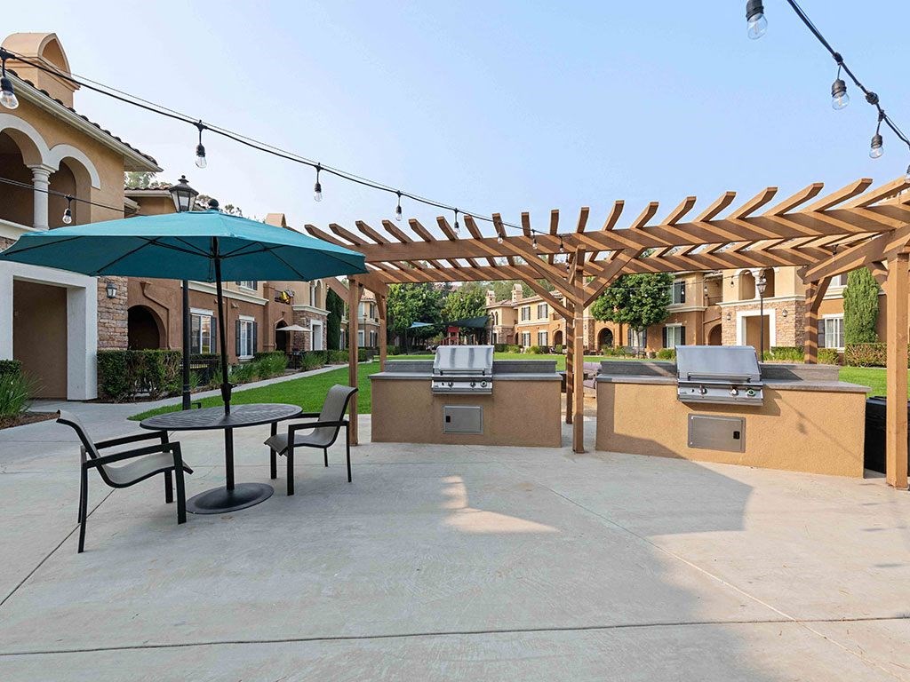 a patio with a table and chairs and umbrellas