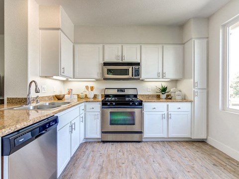 a kitchen with stainless steel appliances and white cabinets