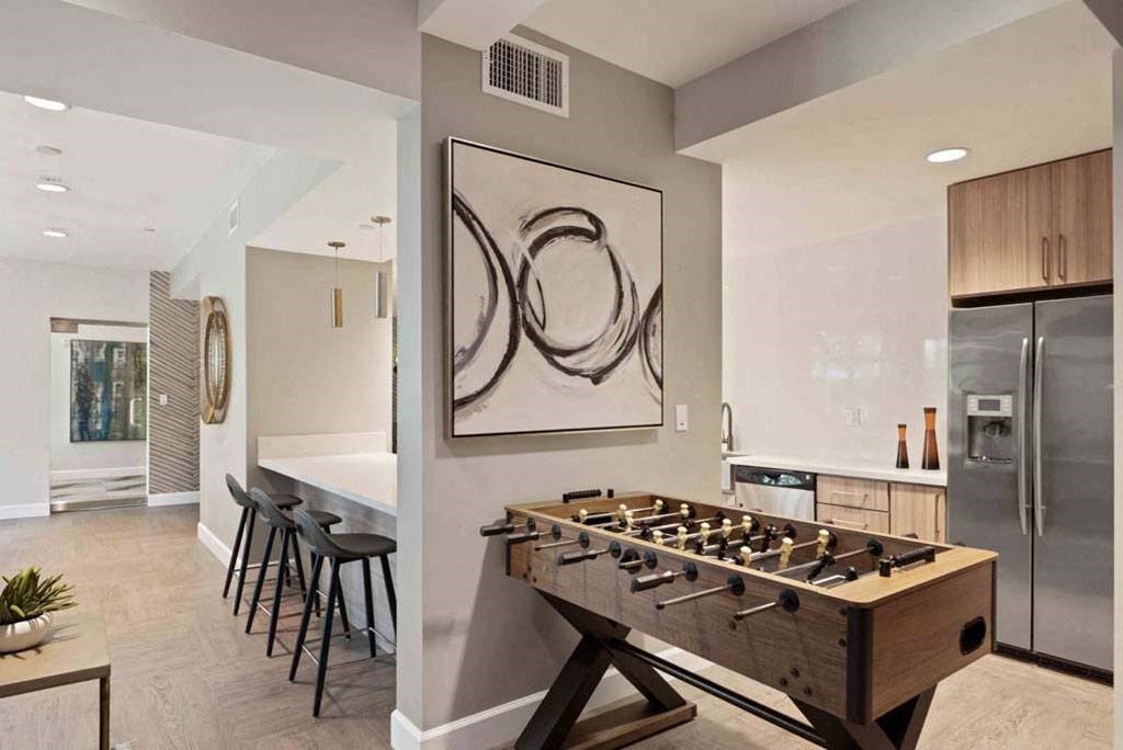 a foosball table in a living room next to a kitchen