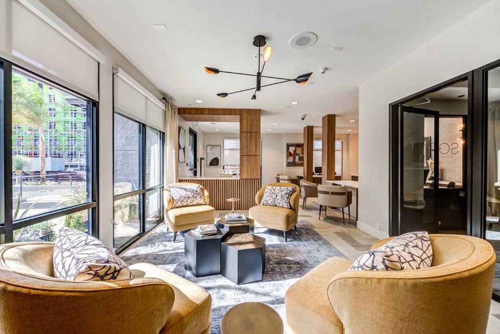 a living room with couches and chairs and a kitchen