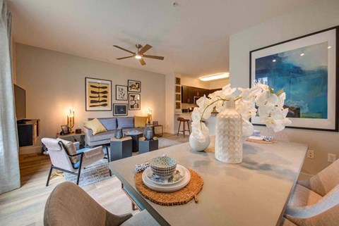 a dining table with a vase on it next to a living room