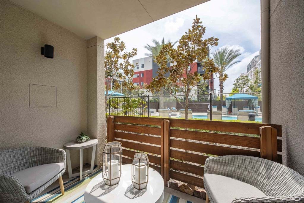 a balcony with a table and chairs and a view of a pool